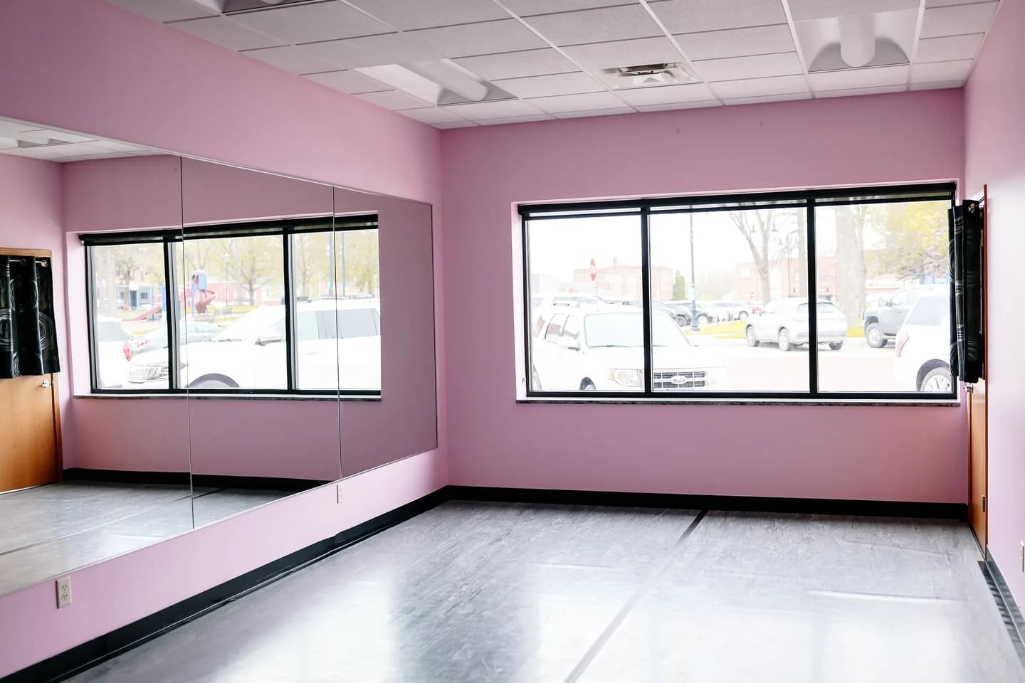 Melinda's Dance Studio Front Small Studio with light pink walls, mirrors, and black dance flooring