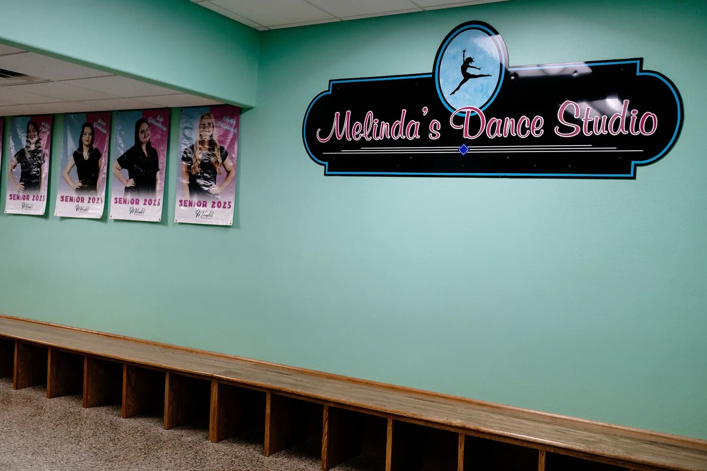 Melinda's Dance Studio lobby and waiting area with studio sign, senior banners, and wooden cubbies